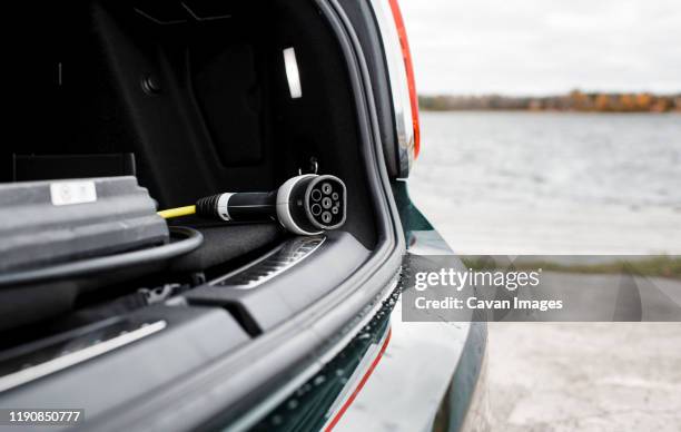 electric car lead in the trunk of a car at the beach - car electro stock pictures, royalty-free photos & images