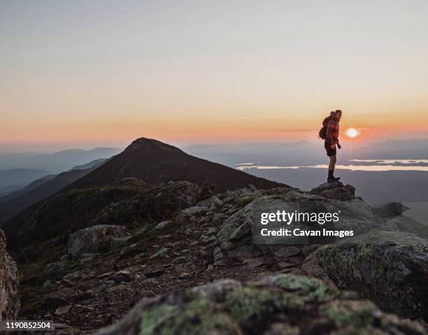 a male hiker stands at the summit of a mountain at sunset, maine. - appalachian trail fotografías e imágenes de stock