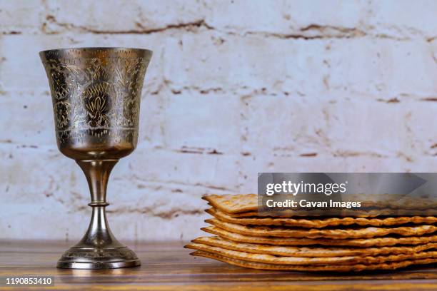 a jewish matzah bread with wine in kiddush cup. passover holiday concept - passover stockfoto's en -beelden