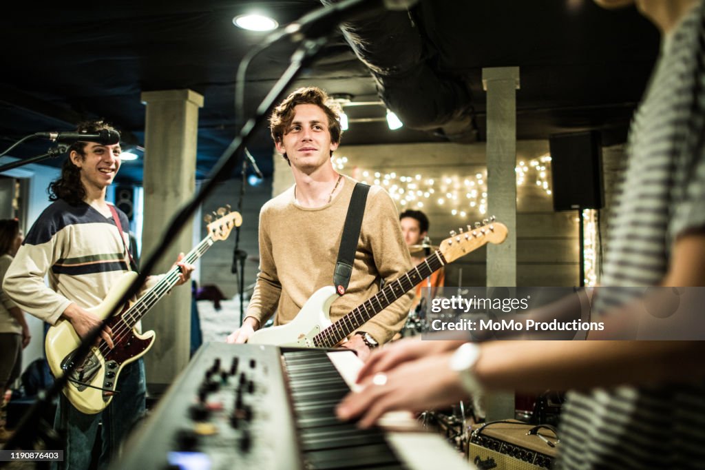 Young rock band rehearsing together and laughing