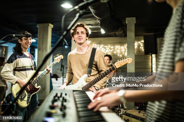 young rock band rehearsing together and laughing - rock musician stock pictures, royalty-free photos & images