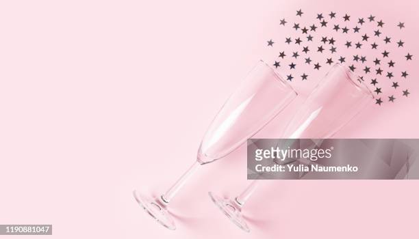 two champagne glasses on pink background with confetti. flat lay, top view, copy space. - champagne flute high angle stock pictures, royalty-free photos & images