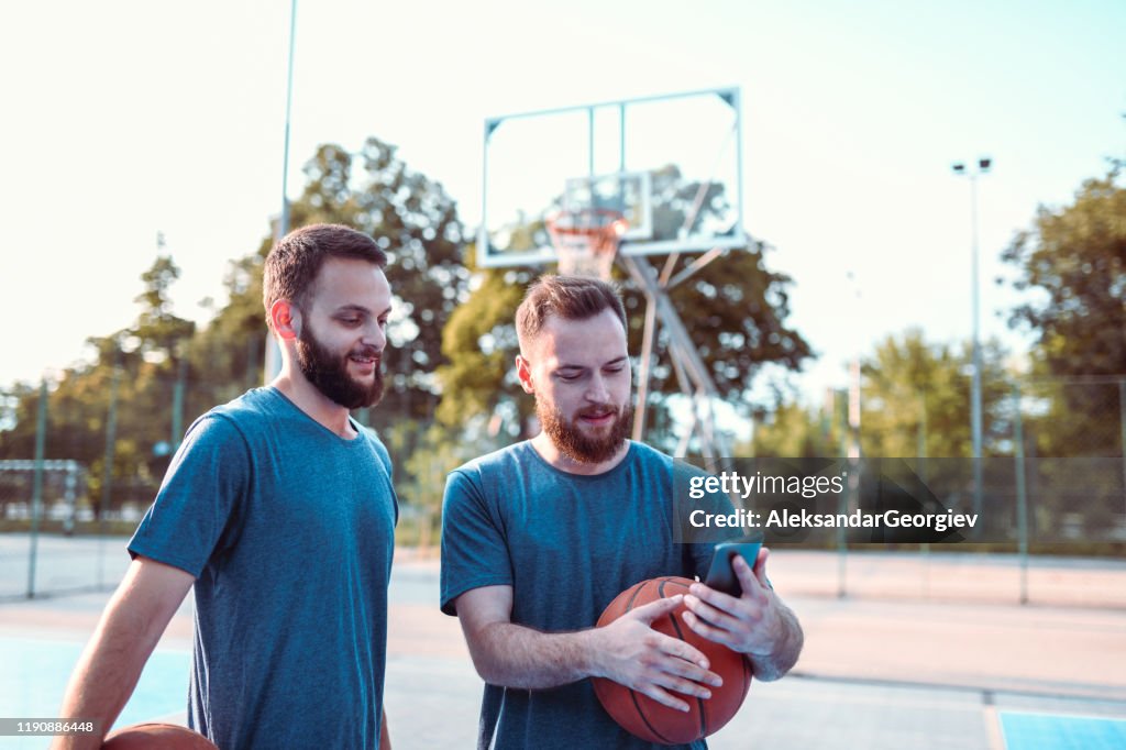 Männliche Athleten versuchen, Basketball bewegt von Smartphone-Video zu replizieren