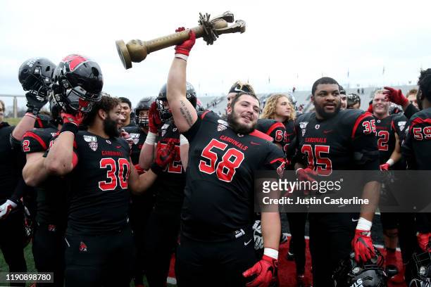 Davion Tyson of the Ball State Cardinals holds up the Red Bird Rivalry trophy after a win over the Miami of Ohio Redhawks at Scheumann Stadium on...