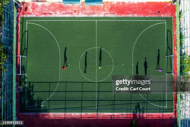 People play football on artificial pitch on December 17, 2019 in Mahibadhoo, Maldives. The Maldives is the worlds lowest lying country with a highest...