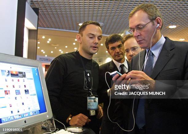 Le ministre de la Culture Jean-Jacques Aillagon teste un appareil portatif qui compresse la musique au format MP3, le 26 janvier 2004 à Cannes, lors...