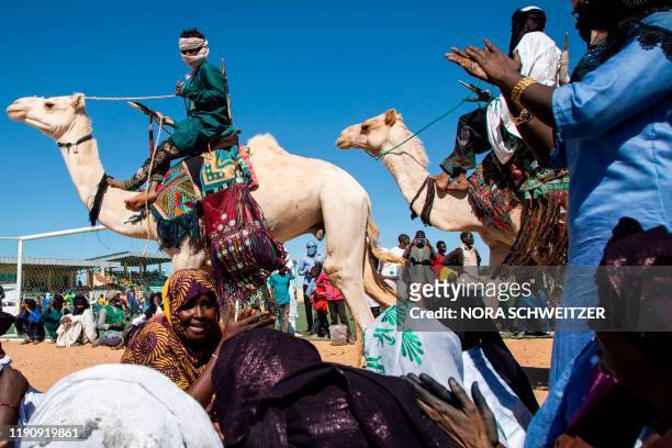 Nomads parade on camels in the Agadez stadium under the songs of Tuareg women, on the occasion of the Grand Marathon du Ténéré on 29 December 2019. -...