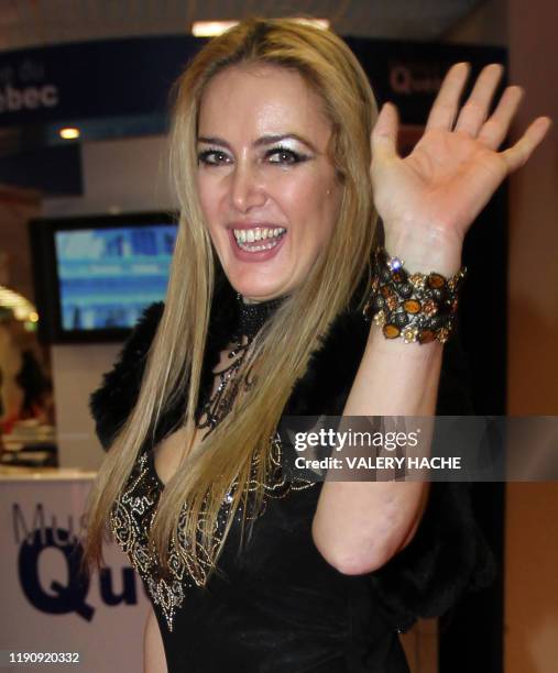 Patrizia d'Addario, the call girl who claims she spent a night with Italian Prime Minister Silvio Berlusconi, waves after presenting her disc with...