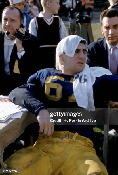 John Cenci of the Pittsburgh Panthers sits on the sidelines with a towel over his head during the 1956 Sugar Bowl Game against the Georgia Tech...