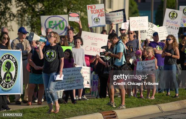 Protest organizer Neringa Zymancius of Darian leads protesters in a chant in front of the Oak Brook headquarters of Sterigenics Friday, Sept. 14,...
