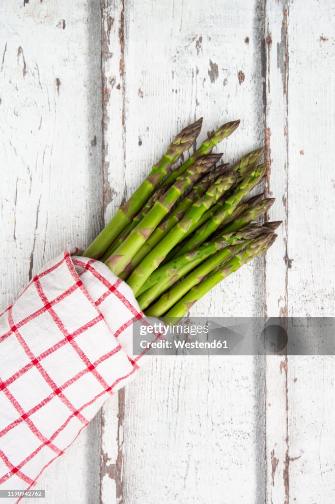 High angel view of green asparagus bunch on wooden table