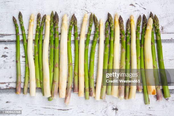 high angel view of white and green asparagus on wooden table - asparagus stock pictures, royalty-free photos & images