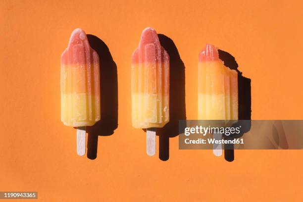 directly above shot of sorbets arranged on orange background - frost bite stock-fotos und bilder