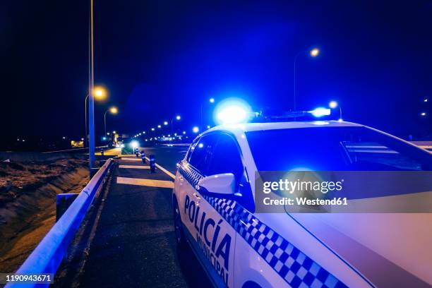 police car patrol on road of madrid during night - polizia foto e immagini stock