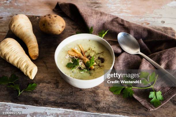 high angle view of oats soup served with ingredients on wooden table - soup vegtables stock-fotos und bilder