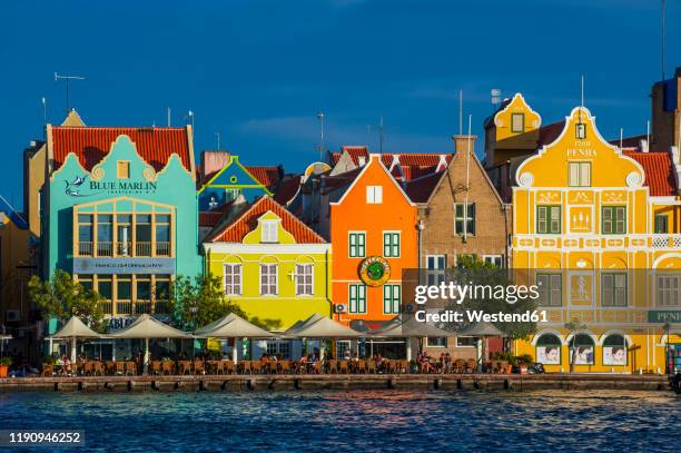 houses by sint annabaai against blue sky in willemstad city during sunny day, curaao - curaçao stockfoto's en -beelden