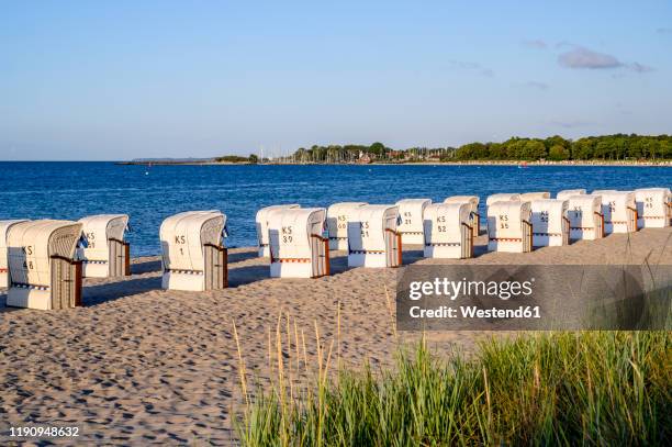 germany, schleswig-holstein, niendorf, strandkorb beach-chairs on sandy coastal beach - beach shelter stockfoto's en -beelden