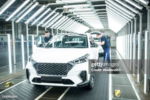 two colleagues working in modern car factory - german auto workers factory stock pictures, royalty-free photos & images
