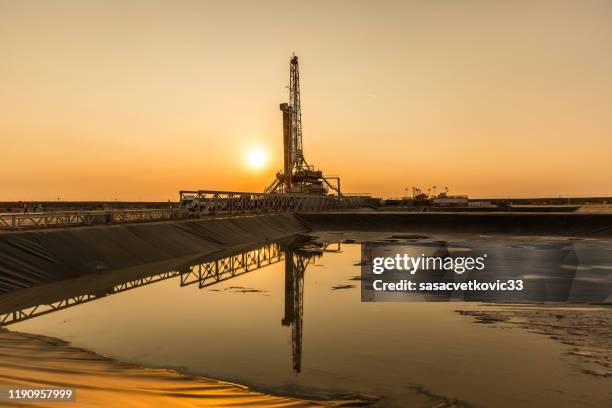 plataforma de fracking de aceite al atardecer - fracking fotografías e imágenes de stock