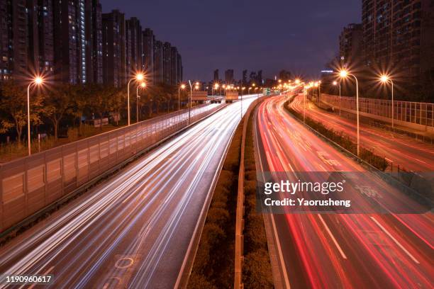 the car light trails in the city - light blur stock-fotos und bilder