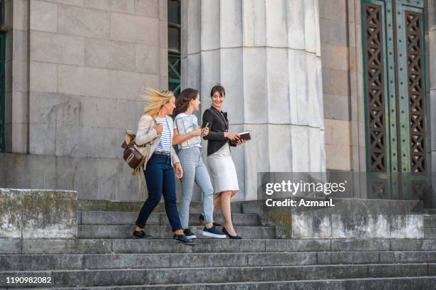 three young female law students departing school building - law student stock pictures, royalty-free photos & images