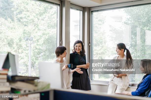 businesswomen having a casual meeting by the window - japanese ストックフォトと画像
