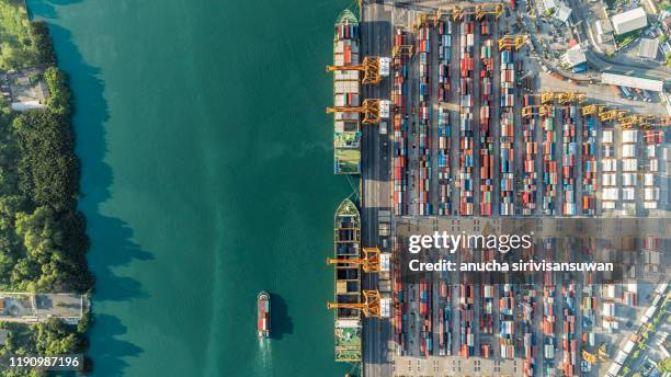 aerial top view container ship crane lifting container for logistic by sea in warehouse. - ship funnel stock-fotos und bilder
