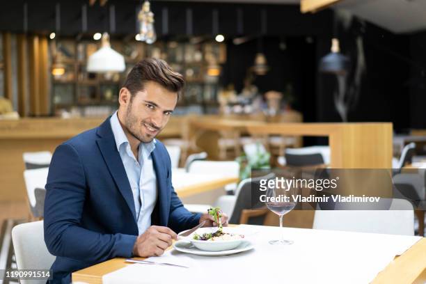 businessman dining in restaurant and drinking red wine - charming men stock pictures, royalty-free photos & images