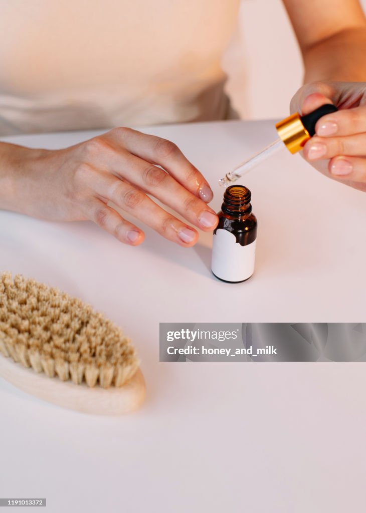 Woman applying cuticle oil to her nails