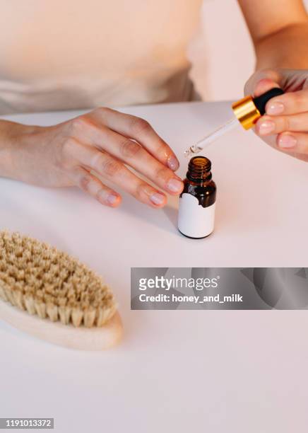 woman applying cuticle oil to her nails - nagelhaut stock-fotos und bilder