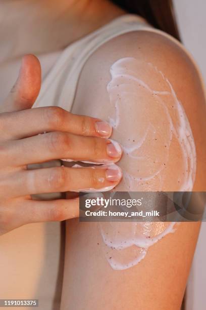 woman rubbing cream on her arm - body scrub stock pictures, royalty-free photos & images