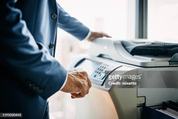 homem de negócios que usa a máquina da fotocópia - fotocopiadora - fotografias e filmes do acervo