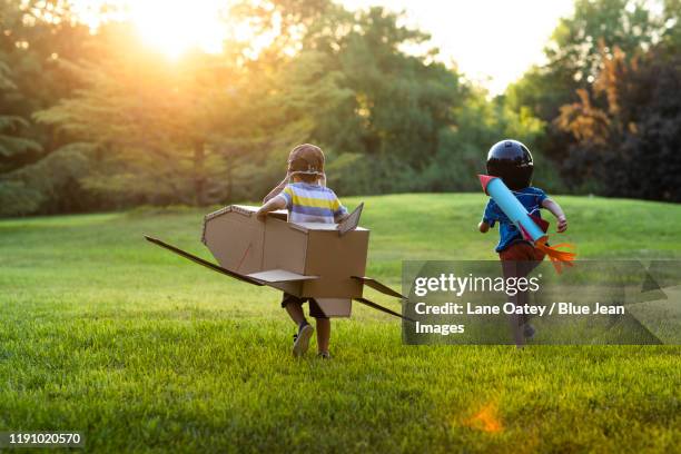 little chinese boys in costume playing on meadow - jet pack stock-fotos und bilder