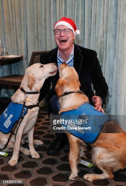 Martin Williams, CEO of M Group with guide dogs, as M Restaurant Victoria Street hosts a Christmas Guide Dog Brunch with The Blind Association on...