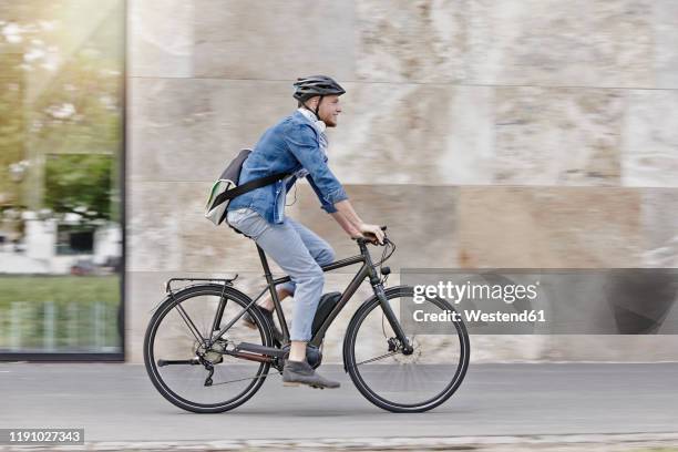 student on his e-bike at goethe university in frankfurt, germany - fahrradfahrer stadt stock-fotos und bilder