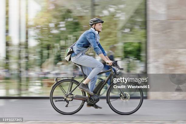 student on his e-bike at goethe university in frankfurt, germany - elektrorad stock-fotos und bilder
