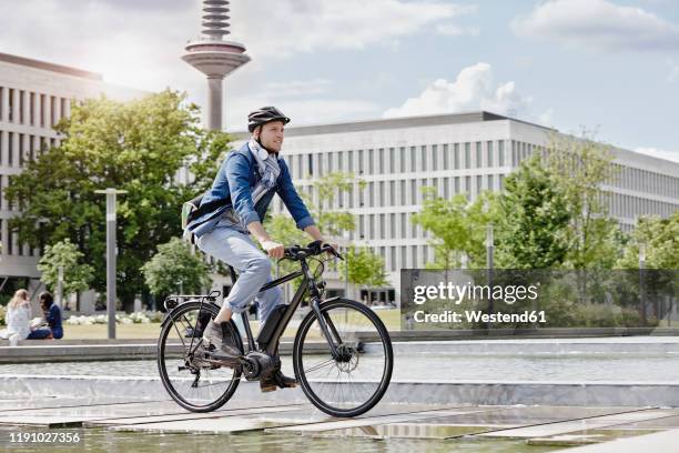 student on his e-bike at goethe university in frankfurt, germany - ebike stock-fotos und bilder