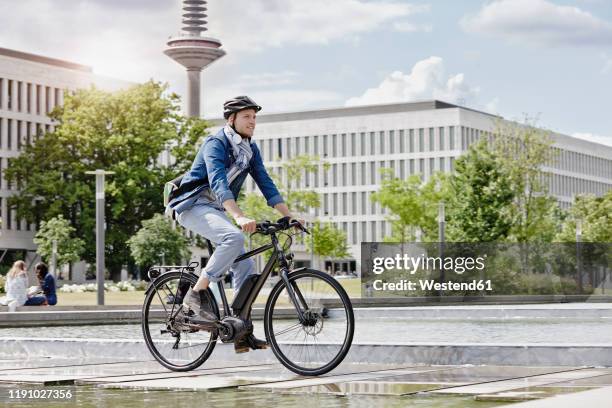 student on his e-bike at goethe university in frankfurt, germany - elektrorad stock-fotos und bilder