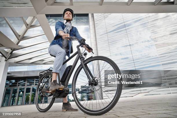 student on his e-bike at goethe university in frankfurt, germany - sports helmet stock pictures, royalty-free photos & images