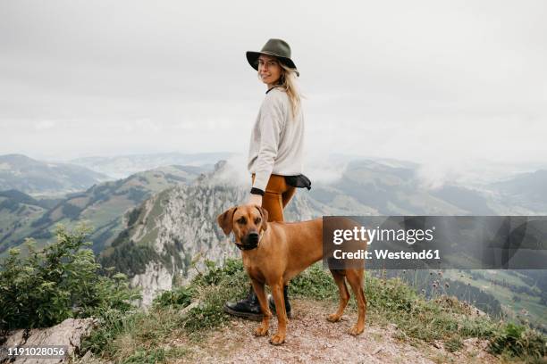 woman with dog on viewpoint, grosser mythen, switzerland - rhodesian ridgeback stock-fotos und bilder