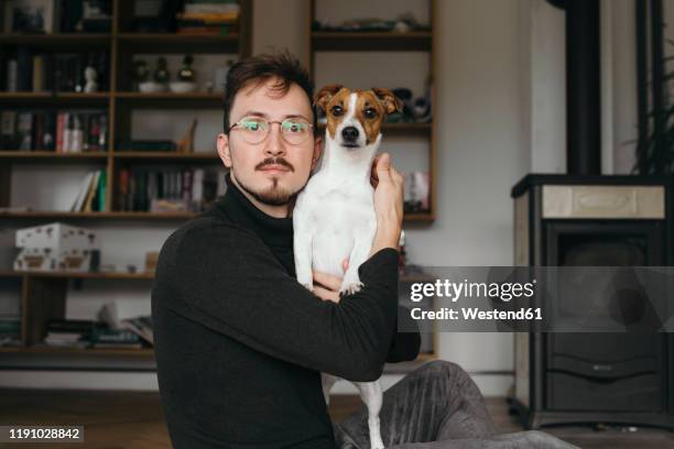 young man with jack russel terrier looking at camera - dog portrait stock-fotos und bilder