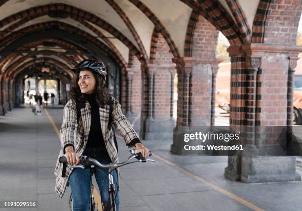 happy woman riding bicycle in the city, berlin, germany - sustainable transportation stock pictures, royalty-free photos & images