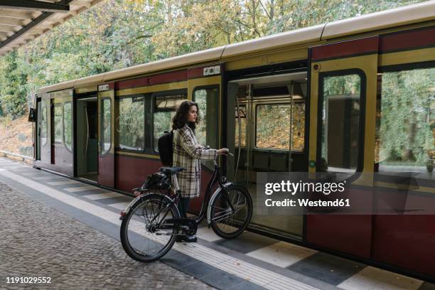 woman with bicycle entering an underground train, berlin, germany - movilidad sostenible fotografías e imágenes de stock