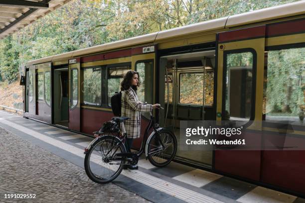 woman with bicycle entering an underground train, berlin, germany - sustainable transportation stock pictures, royalty-free photos & images