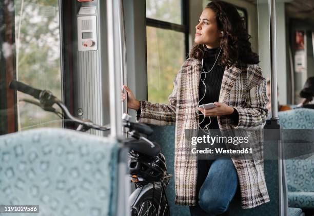 young woman with earphones, smartphone and bicycle on a subway - sustainable transportation stock pictures, royalty-free photos & images