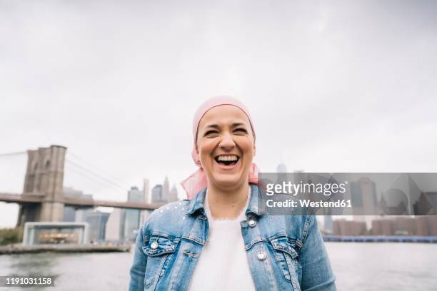 portrait of laughing woman with cancer bandana at brooklyn bridge in new york, usa - cancer portrait bildbanksfoton och bilder