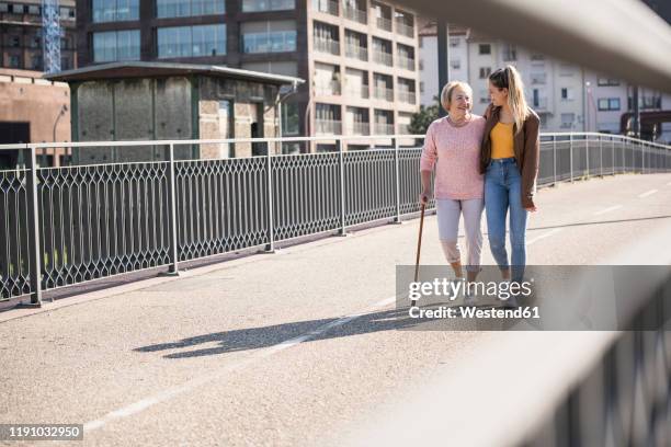 granddaughter and her grandmother walking on footbridge - ponte pedonal imagens e fotografias de stock