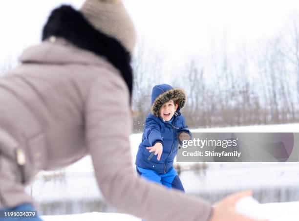 schneeballsystem. glückliche familie mit einem schneeball kampf - schlachtfeld stock-fotos und bilder