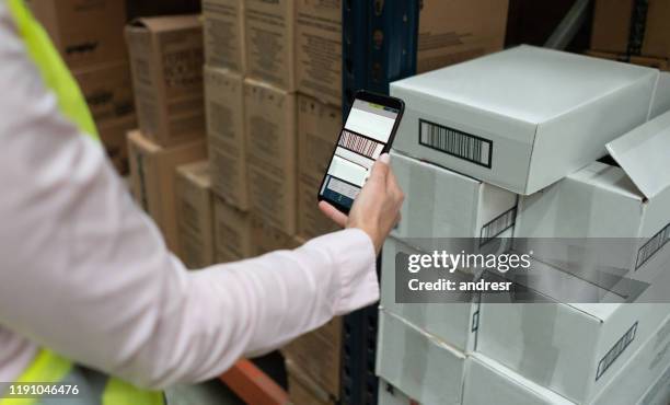 worker scanning products at a distribution warehouse - código-de-barras imagens e fotografias de stock