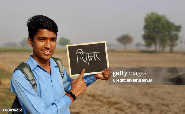 tiener jongen toont schoolbord voor de camera - slate pencil stockfoto's en -beelden